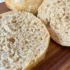 Close up image of whole grain sourdough hamburger buns showing the nice rise and air pockets for this whole grain dough.
