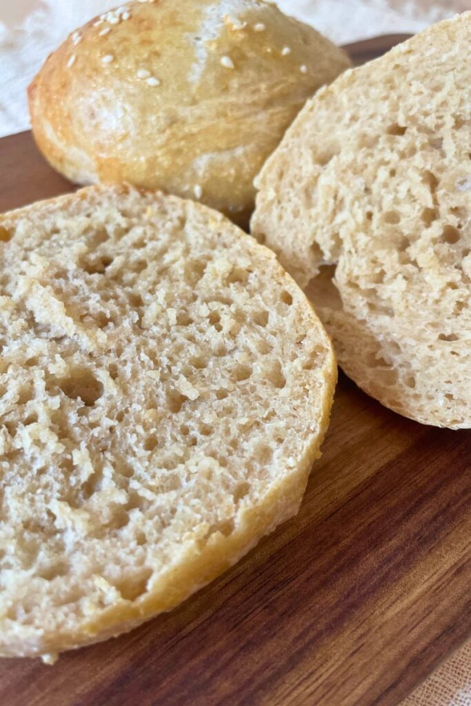 Close up image of whole grain sourdough hamburger buns showing the nice rise and air pockets for this whole grain dough.